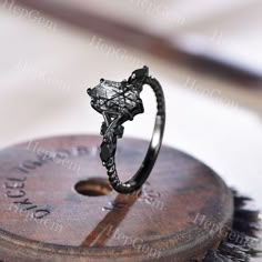 a black diamond ring sitting on top of a wooden box