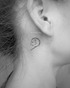 a woman's ear with a small tattoo on the back of her left ear