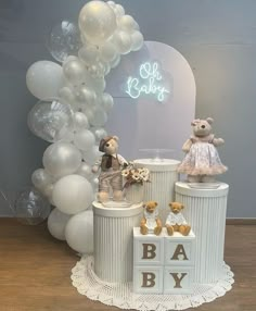 two teddy bears are sitting on top of a baby's crib with balloons in the background