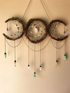 a wall hanging made out of branches and glass beads