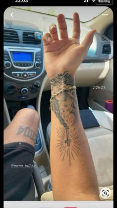 a person's arm with a tattoo on it, and the other hand is holding up