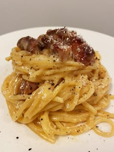 a white plate topped with pasta covered in sauce