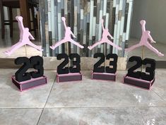 four pink and black trophies sitting on top of a table next to each other in front of a wall