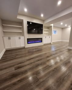 an empty living room with wood floors and built - in entertainment center on the far wall