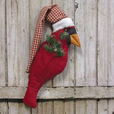 a christmas stocking hanging on the side of a barn door with a duck head