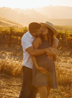 a pregnant couple cuddles in the sun at their vineyard engagement photo by reno photographers