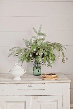 a table with a potted plant sitting on top of it next to a white cabinet