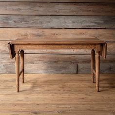 a wooden table sitting on top of a hard wood floor next to a wooden wall