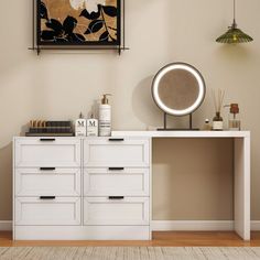 a white dresser sitting next to a mirror on top of a wooden floor in a room