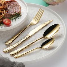 three forks, two spoons and one knife on a plate next to some pasta