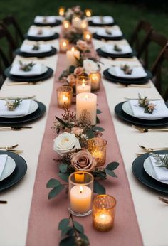 a long table is set with candles and flowers on it for an elegant dinner party