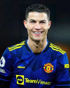 a man in blue and yellow jersey smiling at the camera