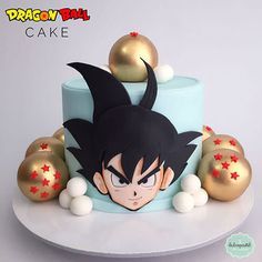 a dragon ball themed cake on a white plate with gold balls around it and an image of gohan's face