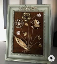 a framed painting with flowers and leaves on it