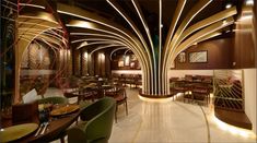 the interior of a restaurant with wooden tables and green chairs, along with gold accents