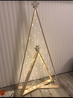 a christmas tree made out of wood with lights on it and a star hanging from the top