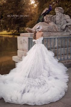 a woman in a wedding dress standing next to a statue