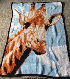 an orange and white giraffe on a blue background is crocheted onto a blanket