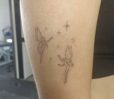 a woman with a tattoo on her leg that has two birds flying in the sky