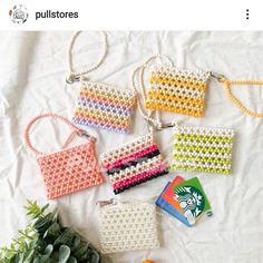 several purses are shown on a bed next to some succulents and an orange