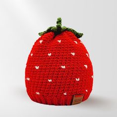 a crocheted strawberry hat with hearts on it