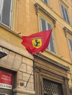 a red ferrari flag on the side of a building