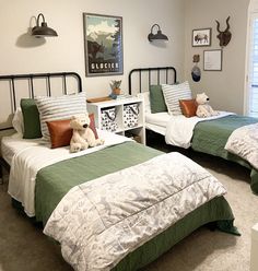 two twin beds in a bedroom with green and white bedding, one has a teddy bear on it