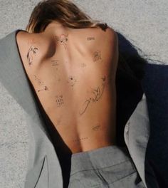 the back of a woman's body with tattoos on her upper and lower back