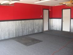 an empty room with red walls and metal partitions