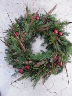 a christmas wreath with pine cones and red berries