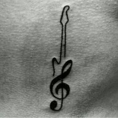 a black and white photo of a musical note on the back of a woman's stomach