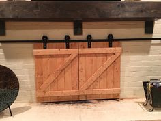 a large wooden door sitting on top of a white brick wall next to a fireplace