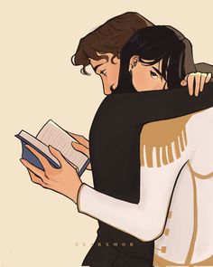 two people hugging each other while holding an open book