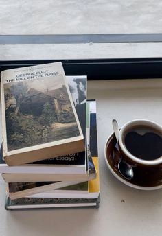 a cup of coffee and some books on a table