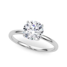 a white gold engagement ring with a round cut diamond in the center, on a plain surface