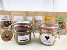 three jars filled with different types of food on top of a table next to bags of coffee