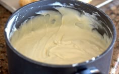 a metal bowl filled with batter on top of a counter