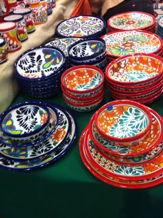 many colorful plates and bowls are on display