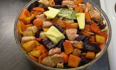 a bowl filled with meat and veggies on top of a counter next to an oven