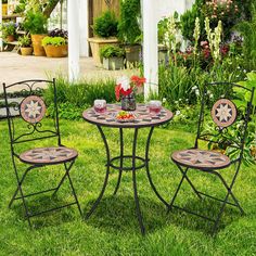 an outdoor table and chairs set up in the grass