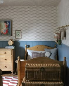 a bedroom with a bed, dresser and chest of drawers in front of the wall