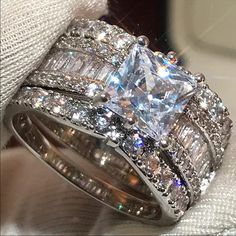 an engagement ring and wedding band set with princess cut diamonds on the sides, in white gold