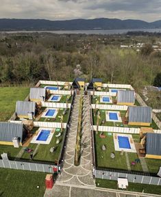 an aerial view of a house with swimming pooles and green grass on the roof