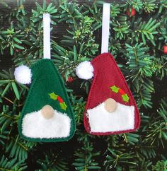 two felt christmas hats hanging from a tree