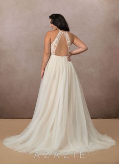 a woman in a white wedding dress with an open back and beaded neckline