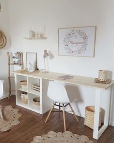 a white desk sitting on top of a wooden floor next to a chair and table