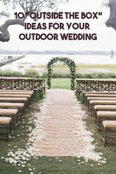 an outdoor ceremony set up with chairs and flowers on the aisle, along with greenery