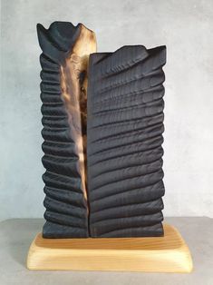 a black vase sitting on top of a wooden stand