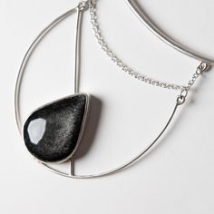 This one of a kind statement piece is hand fabricated in sterling silver, with a beautiful silver sheen obsidian. Collar size is slightly adjustable. Handcrafted in San Francisco. In stock and ready to ship. Adjustable Silver Obsidian Necklace, Silver Obsidian Pendant Necklace, Silver Obsidian Gemstone Necklace, Black Sterling Silver Jewelry, Modern Silver Agate Jewelry, Silver Obsidian Necklaces, Silver Agate Teardrop Pendant Jewelry, Silver Obsidian Necklace With Natural Stones, Modern Adjustable Jewelry With Large Stone