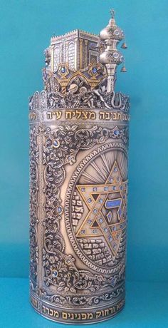 an ornate silver and gold canister on a blue background